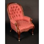 A Victorian mahogany spoon back armchair, deep-button stuffed-over upholstery, scroll arms,