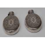 Tiffany & Co - a pair of 19th century sterling silver oval hip flasks,