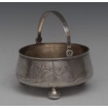 A Russian silver swing handled circular bowl, engraved with lilies on sinuous stems, ball feet,