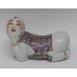 A Chinese Republican period figural pillow, as a young boy, kneeling,