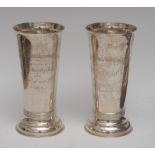 A pair of silver flared cylindrical vases, ribbed and spreading circular base, engraved, 19cm high,