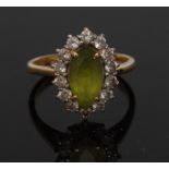 A peridot and diamond cluster ring, central oval green peridot,