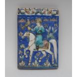 A Persian rectangular tile, decorated in relief in blue,