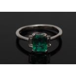 An emerald and diamond trilogy ring, central rectangular baguette emerald approx 1.