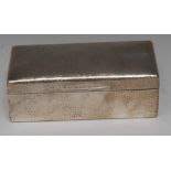 An Edwardian silver table cigarette box, planished overall,