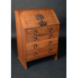 An Arts and Crafts iron-mounted oak bureau, fall front enclosing an arrangement of pigeon holes,