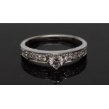 An eleven stone diamond ring, central raised princess cut square diamond,