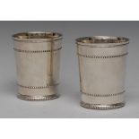 A pair of Victorian silver tapered cylindrical beakers, beaded borders and girdles, gilt interiors,