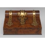 A Victorian walnut and brass mounted slope front stationery box, applied with brass Gothic straps,