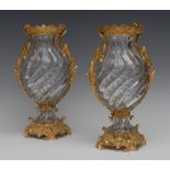A pair of Rococo design ormolu mounted crystal wrythen ovoid mantel vases, possibly Baccarat,