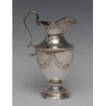 A George III silver urnular pedestal cream jug, embossed with swags, beaded borders,