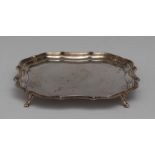 A George V silver shaped square waiter, of 18th century design, fluted piecrust border, plain field,