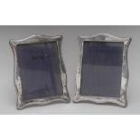 A pair of George V silver shaped rectangular easel photograph frames, 26cm high, W J Myatt & Co,