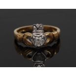 A diamond Claddagh ring, central heart diamond beneath diamond accented crown, open hands shoulders,