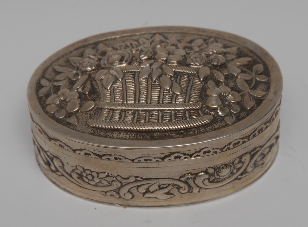 A Dutch silver oval table snuff box, hinged cover embossed with a basket of flowers,