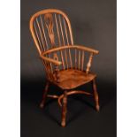 An early 19th century elm Windsor elbow chair, low hooped back with shaped and pierced splat,