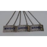 A set of three Elizabeth II silver and enamel curved rectangular wine labels, Brandy,