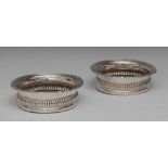 A matched pair of George IV silver shaped circular wine coasters, gadrooned leafy scroll rims,