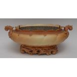 A Royal Worcester boat shaped lobed planter, in blush ivory, leafy scroll handles and base, in pink,