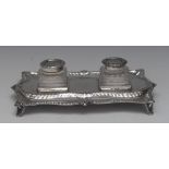 A George III silver shaped serpentine inkstand, gadrooned borders, square cut clear glass bottles,