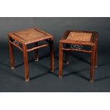 A pair of Chinese padouk square stools, each with a caned above a deep frieze pierced with scrolls,