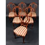 A set of six Victorian mahogany dining chairs, pierced cartouche-shaped backs, stuffed-over seats,