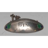 A silver and enamel curved navette shaped wine label, Gin, applied with fruiting vine,