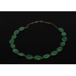 A carved green jade panel necklace, composed of sixteen oval panels each carved with fruit,