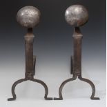 A large pair of steel andirons, disc terminals, arched feet,