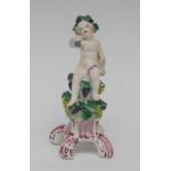 A Bow figure, Allegorical of Autumn, modelled with a cherub wearing a grape chaplets,