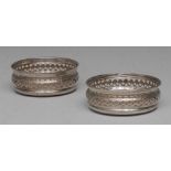 A pair of George III style silver coasters, pierced and bright-cut engraved borders,