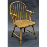 An early 19th century elm Windsor elbow chair, arched stick back, deep saddle seat,