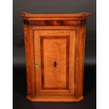 A George III oak and mahogany splay-fronted wall-hanging corner cupboard,