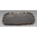 A George VI shaped square salver, of George II design, plain field, piecrust border, lion paw feet,