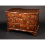 A mid-18th century walnut chest, quarter-veneered moulded oversailing top above three long drawers,