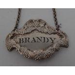A heavy George IV cast silver cartouche shaped cut out wine label, Brandy, fruiting vine border,
