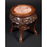 A Chinese hardwood circular jardiniere stand, inset marble top above a deep frieze,