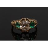 An emerald and diamond ring, central cushion Old Cut diamond,