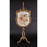 A substantial Rococo Revival giltwood pole screen,