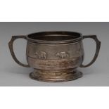 An Indian silver two-handled bowl, chased with bears on a textured ground, angular scroll handles,