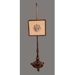 A William IV rosewood pole screen, rounded rectangular wool work banner, turned column, lotus socle,