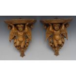 A pair of Italian softwood wall brackets, carved as putto amongst scrolling acanthus,