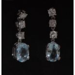 A pair of pale blue and white stone droplet earrings, each with an oval pale blue stone terminal,