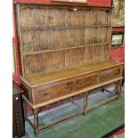 An 18th/19th century oak and pine dresser, the top with two shelves, the base with three drawers,