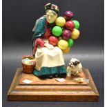 A Royal Doulton figural group, Balloon Seller and Dog (faults),