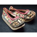 A pair of Chinese silk lady's shoes, embroidered with flowers and further foliage,