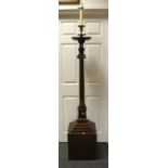 An early-20th century oak substantial standard lamp, brass fittings, above oversailing plinth top,