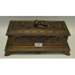 A Black Forest table box, hinged cover carved with flowers, the side with vine, c.
