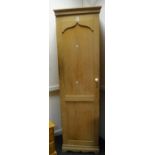 An early 20th century pine hallrobe, single cross banded shield shaped paneled door,