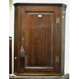An oak wall mounted corner cupboard, canted front,